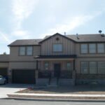 Plan 288-0265 Front view of a two-story home with stone accents and garage